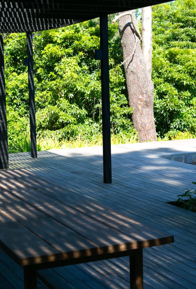 Área del parrillero de Brown refugiado bajo una pérgola y conectando con el deck con piscina